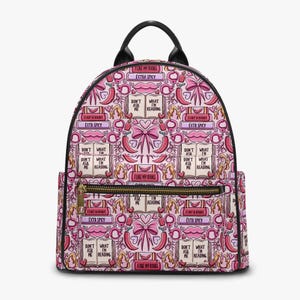 May include: Pink backpack featuring a repeating pattern of books, chilli peppers, bows, and lips. Text on the bag includes "I like my books," "Extra Spicy," and "Don't ask me what I'm reading."