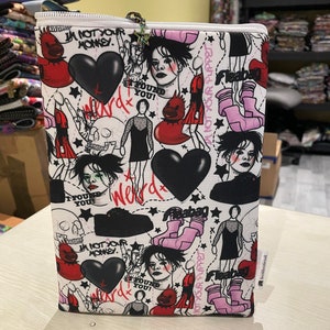 May include: White zippered pouch with a black and white graphic print featuring a skull, hearts, stars, and the text "I'm not your monkey" and "Found you!" The pouch also features a pink and white graphic print of a pair of boots with the text "Fleabag" and "Not your puppet".
