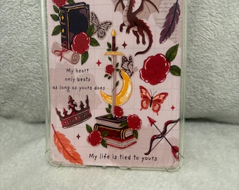 Op de afbeelding: Transparante telefoonhoes met een roze achtergrond met een draak, rozen, vlinders, een kroon en een zwaard. De hoes heeft de tekst "My heart only beats as long as yours does" en "My life is tied to yours".