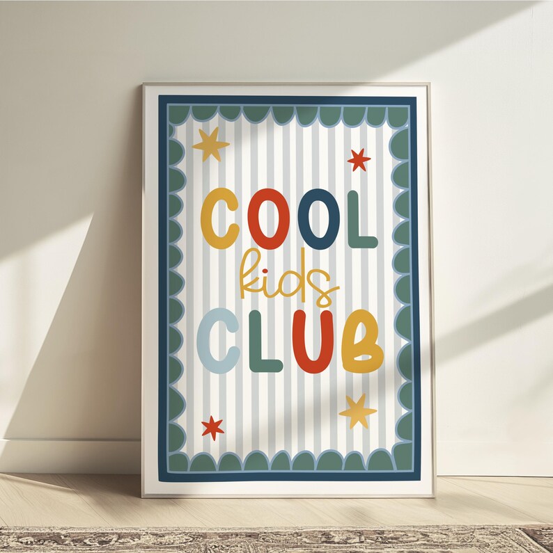 May include: A framed print with the words "COOL kids CLUB" in colorful letters. The background has vertical stripes and a scalloped border. Stars are scattered around the text.