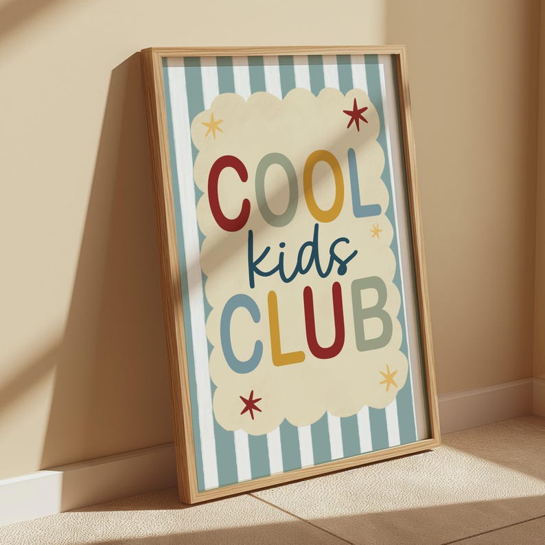 May include: A framed print with the words "COOL kids CLUB" in colorful letters. The background has a light blue and white striped pattern with a cream-colored cloud shape behind the text. Small star shapes are scattered around the text.