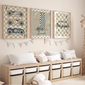 May include: Three framed prints with a racing car theme. The first print features three racing cars with numbers 1, 2, and 3. The second print features a chequered flag and the name Jonah. The third print features a chequered background with the text "Long Live Boyhood".
