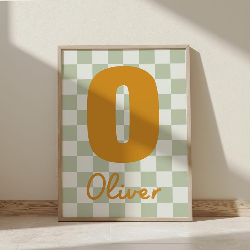 Puede incluir: L&aacute;mina art&iacute;stica enmarcada con un gran n&uacute;mero "0" amarillo mostaza sobre un fondo a cuadros verde y blanco. El nombre "Oliver" est&aacute; escrito en una fuente amarilla mostaza a juego debajo. La obra est&aacute; en un marco de madera clara.