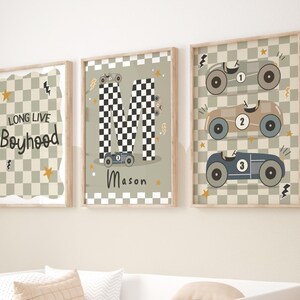 May include: Three framed prints with a racing car theme. The first print has a chequered background and the text "Long Live Boyhood". The second print has a chequered "M" with a racing car in front of it and the name "Mason" below. The third print has a chequered background with three racing cars stacked on top of each other.