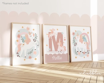 May include: Three pink and white framed prints with illustrations of unicorns, flowers, and rainbows. The middle print features the letter "M" and the name "Mollie".