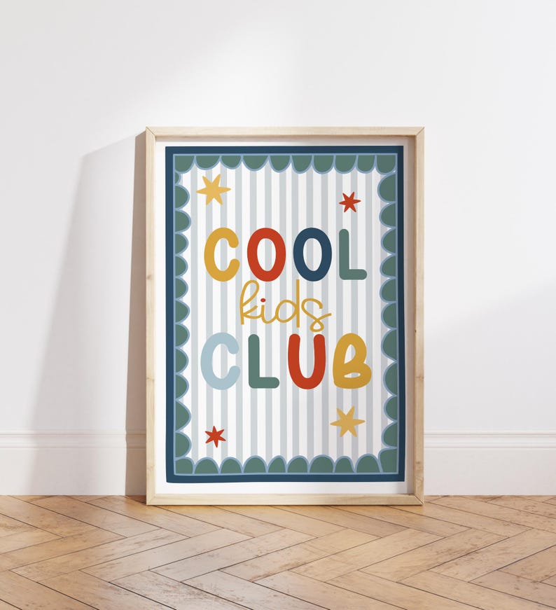 May include: A framed print with the words "COOL kids CLUB" in colorful, playful lettering. The design features a striped background, star accents, and a scalloped border, all within a light wood frame.