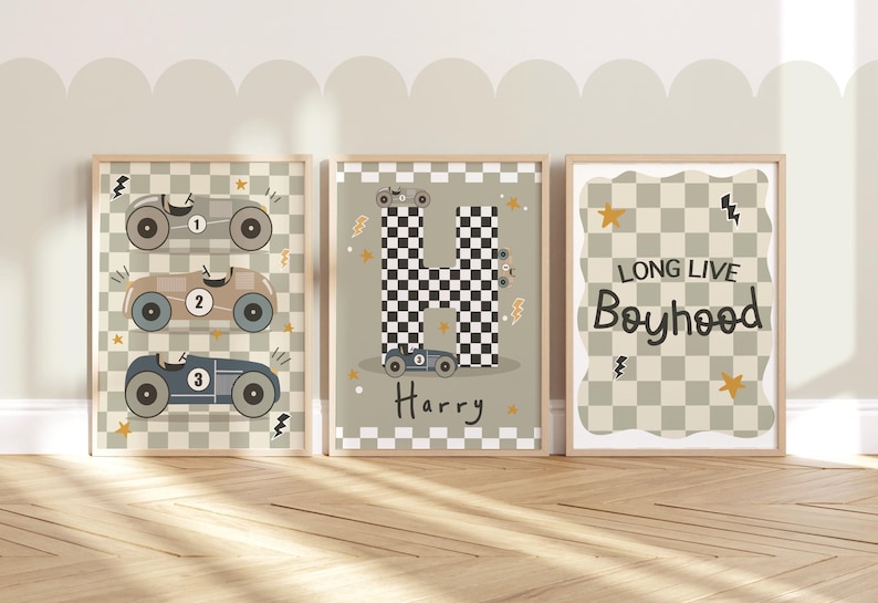 May include: Three framed prints with a chequered background and racing car illustrations. The first print features three racing cars with the numbers 1, 2, and 3. The second print features a chequered letter H with a racing car and the name Harry. The third print features the text "Long Live Boyhood".