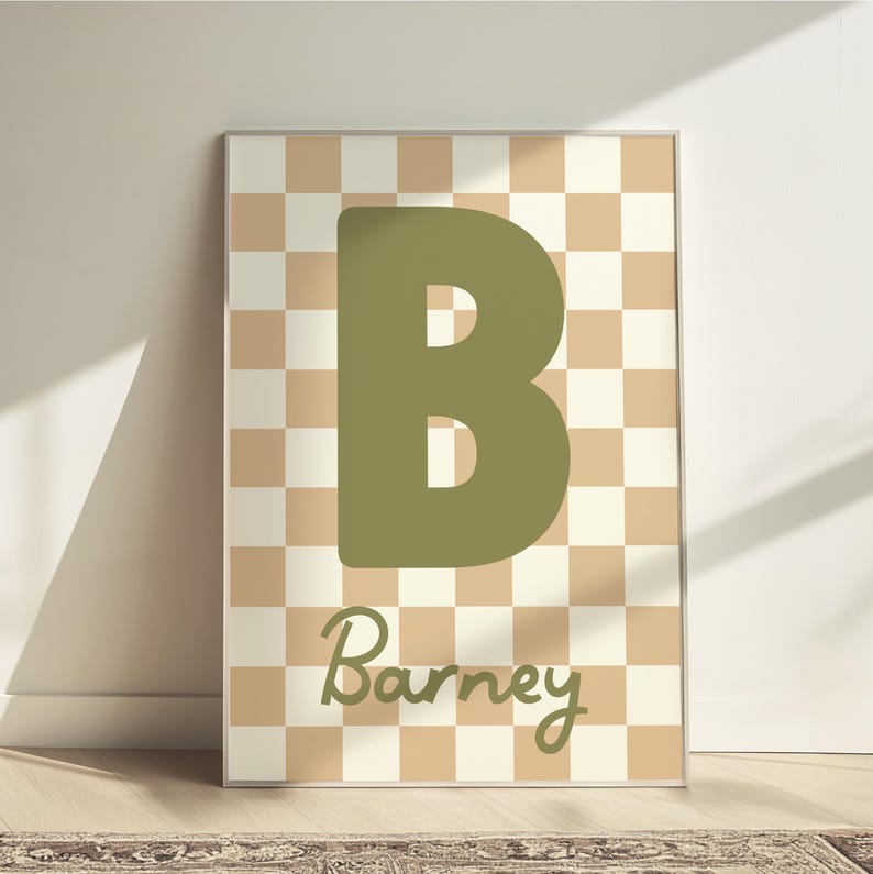 Puede incluir: Arte mural enmarcado con una gran letra "B" verde oliva sobre un fondo a cuadros beige y crema. El nombre "Barney" est&aacute; escrito en cursiva debajo de la letra.
