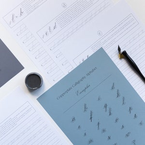 May include: A blue sheet of paper with the title "Copperplate Calligraphy Alphabet Exemplar" and a grid of lowercase letters written in copperplate calligraphy.