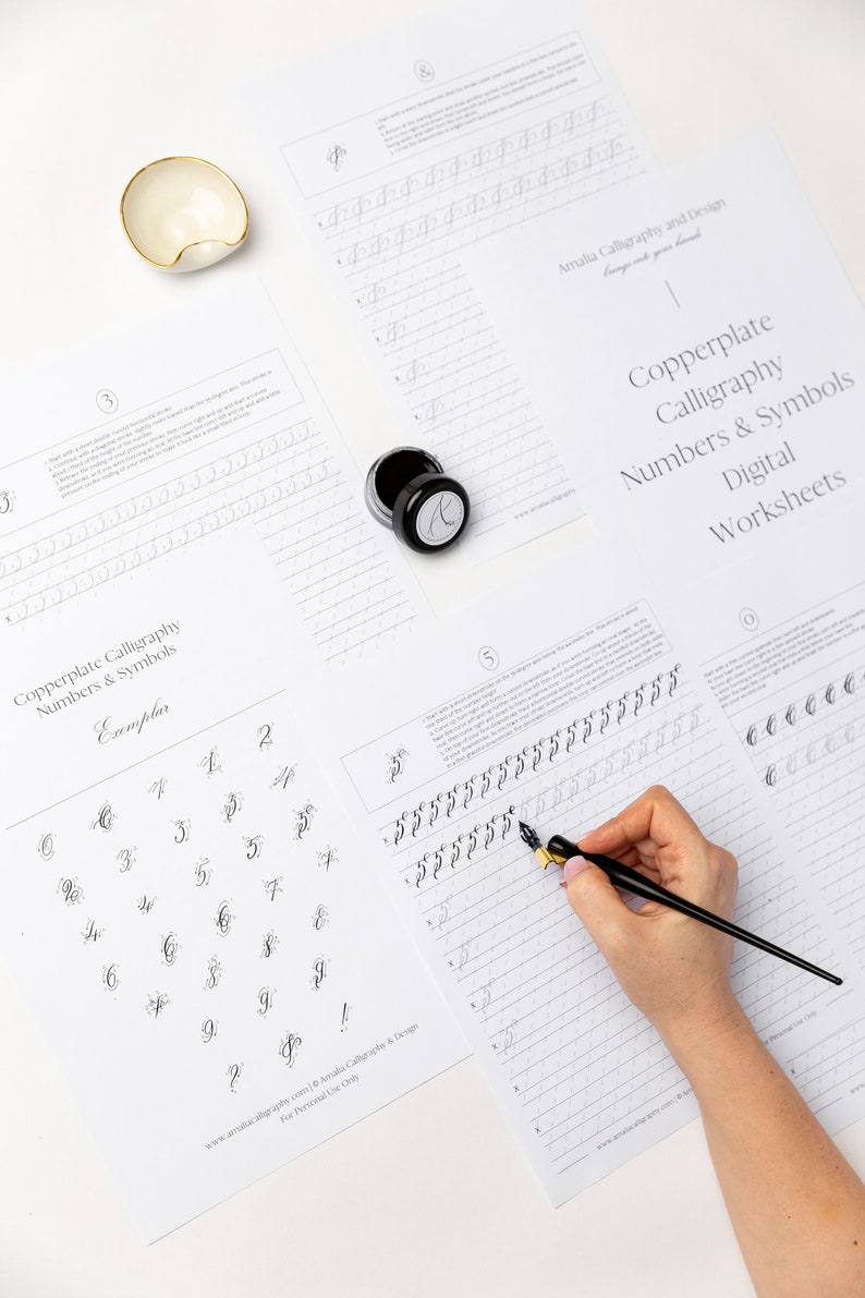 May include: A set of digital worksheets for copperplate calligraphy featuring numbers and symbols. The worksheets include an exemplar of each number and symbol, as well as practice lines for writing. The image shows a person practicing calligraphy with a dip pen and ink.