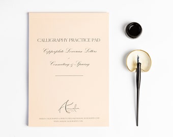 May include: A peach-colored calligraphy practice pad with the text "Calligraphy Practice Pad", "Copperplate Lowercase Letters", and "Connecting & Spacing". The pad also includes the signature "Amalia" and the website address "www.amaliacalligraphy.com".