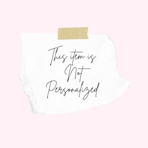 May include: A torn piece of white paper with the text "This item is Not Personalized" in black script, taped to a light pink background with a piece of tan tape.