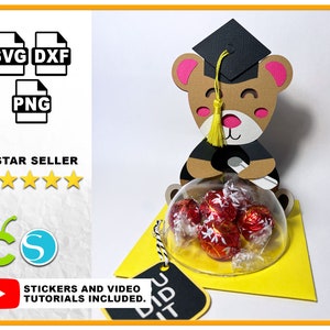 May include: A graduation-themed bear-shaped gift box with a clear dome containing wrapped candies. The bear wears a graduation cap and gown. The image includes the text "SVG DXF PNG" and "5 STAR SELLER". A yellow tag reads "GRAD".