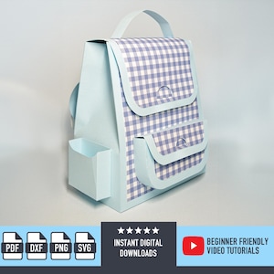 Op de afbeelding: Een lichtblauwe papieren rugzak met een ruitpatroon op de voorklep en zakken. De rugzak heeft een handvat en een zijvak. De afbeelding bevat ook pictogrammen voor PDF-, DXF-, PNG- en SVG-bestanden, samen met de tekst "DIRECTE DIGITALE DOWNLOADS" en "BEGINNERVRIENDELIJKE VIDEOTUTORIALS."