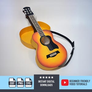 Puede incluir: Guitarra acústica con un acabado degradado amarillo y naranja, golpeador negro y correa negra. La guitarra descansa sobre un estuche amarillo. La imagen también incluye el texto "INSTANT DIGITAL DOWNLOADS" y "BEGINNER FRIENDLY VIDEO TUTORIALS".