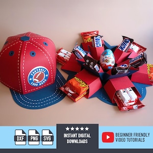Pode incluir: Um boné de futebol de papel vermelho com aba azul e um logotipo de futebol. O boné está ao lado de uma caixa explosiva vermelha e azul cheia de barras de chocolate e um ovo Kinder Surpresa. A imagem inclui o texto "DOWNLOADS DIGITAIS INSTANTÂNEOS".