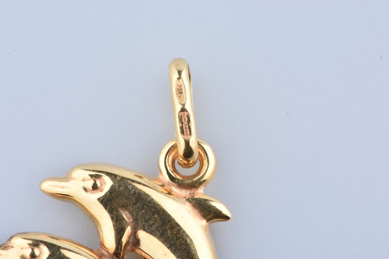 Two dolphin pendant in 9 carat yellow gold with beaker.