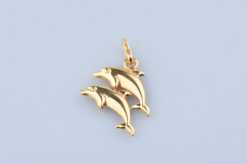 Two dolphin pendant in 9 carat yellow gold with beaker.