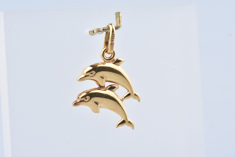 Two dolphin pendant in 9 carat yellow gold with beaker.