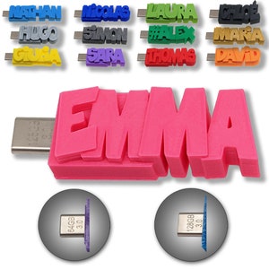 Könnte beinhalten: Ein pinkfarbener USB-Stick mit dem Namen "EMMA" in großen, fetten Buchstaben. Der Stick hat einen USB-C-Anschluss und ist in den Speichergrößen 64 GB und 128 GB erhältlich.