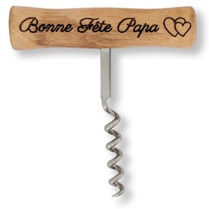 Könnte beinhalten: Ein Korkenzieher aus Holz mit einer Metallspirale und einem Griff, auf dem "Bonne Fête Papa" mit zwei Herzen steht.