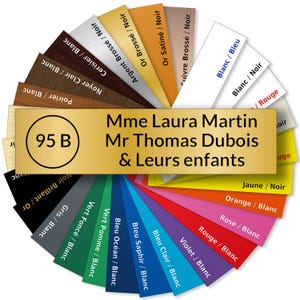 May include: A gold plaque with the text "Mme Laura Martin Mr Thomas Dubois & Leurs enfants" and the number "95 B" in a circle. The plaque is surrounded by a color wheel of different finishes, including wood, metal, and plastic.