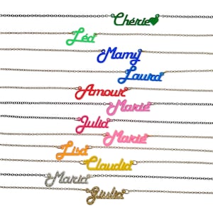 May include: A collection of necklaces with various names written on them in different colors. The names include Chérie, Led, Mamy, Laurad, Amour, Marie, Julia, Lisa, Claudia, Marid, and Jula.