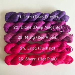 May include: Five skeins of yarn in shades of purple, pink, and red. The yarn is labeled with the names and colors: Lara (Deep Purple), Diane (Deep Magenta), Misty (Red Violet), Erica (Fuchsia), and Sherri (Hot Pink).