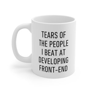 May include: White ceramic coffee mug with black text that reads "Tears of the people I beat at developing front-end".