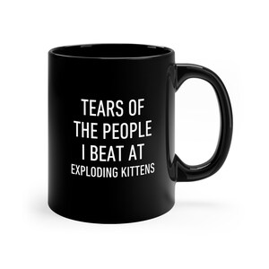 a black coffee mug with the words tears of the people i beat at exploding kitten