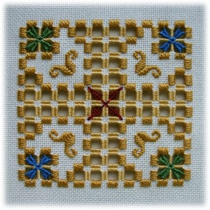 May include: A square embroidery design with a grid pattern in gold thread. The centre of the design features a red four-pointed star. The corners of the design feature four-leaf clover and four-pointed star motifs in green and blue thread.