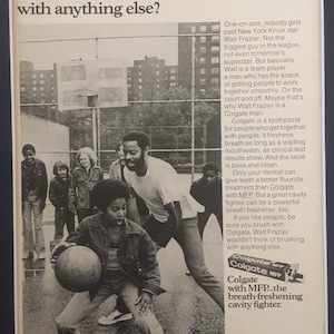 May include: Black and white photo of a basketball player, Walt Frazier, with a group of children. The ad features the text "If Colgate is just a kid's cavity fighter, how come Walt Frazier won't brush with anything else?" and a Colgate toothpaste tube with the text "Colgate with MFP...the breath-freshening cavity fighter."