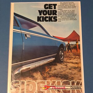 May include: An advertisement for Thrush Outsiders sidekick mufflers. The image features a blue car with chrome side pipes, set against a desert backdrop. Text reads "Get Your Kicks" and "Sidekick".