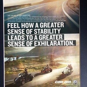May include: A Can-Am Spyder Roadster motorcycle advertisement featuring a black and red motorcycle on a winding road. The text reads "Feel how a greater sense of stability leads to a greater sense of exhilaration."