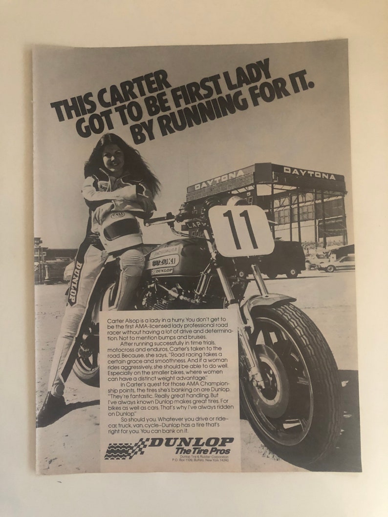 Pode incluir: Uma fotografia a preto e branco de uma mulher a correr de mota numa pista. A mota tem um pneu Dunlop. O texto "This Carter got to be first lady by running for it." est&aacute; no topo da imagem. O texto "Dunlop The Tire Pros" est&aacute; na parte inferior da imagem.