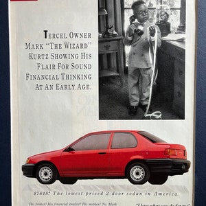 May include: A red Toyota Tercel sedan with the tagline "$7848. The lowest-priced 2-door sedan in America." and the slogan "I love what you do for me."  The image also features a young boy on the phone, with the text "Tercel Owner Mark "The Wizard" Kurtz Showing His Flair For Sound Financial Thinking At An Early Age."