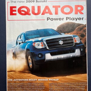 May include: A blue 2009 Suzuki Equator pickup truck is parked on a dirt road. The truck has a black grille and a silver bumper. The text "The new 2009 Suzuki Equator™ Power Player -" is at the top of the image. The text "THE ADVENTURE-READY MIDSIZE PICKUP" is at the bottom of the image.