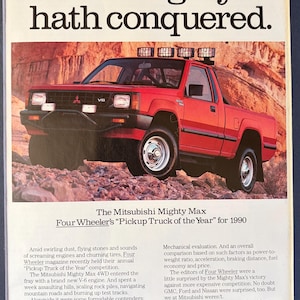 May include: An advertisement for the Mitsubishi Mighty Max pickup truck. The red truck is shown on a rocky terrain. The text reads "The Mighty hath conquered." and "Four Wheeler's 'Pickup Truck of the Year' for 1990."