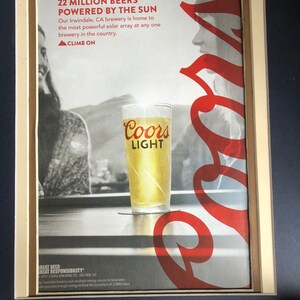 May include: An advertisement for Coors Light beer. The image features a glass of beer with the Coors Light logo, and the text "22 MILLION BEERS POWERED BY THE SUN". The ad includes the phrase "CLIMB ON".