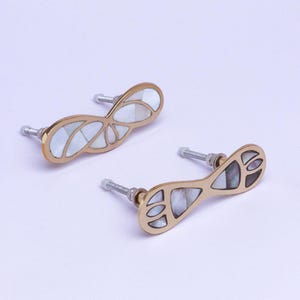 Può includere: Due pomelli decorativi per mobili con finitura dorata e intarsi in madreperla. I pomelli hanno un design astratto unico. L'hardware è ideale per aggiungere un tocco di eleganza ai mobili.