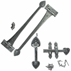 May include: A set of antique-style, grey metal hardware components. The collection features two long hinges, a heart-shaped handle, a latch, and various screws and a chain. The hardware has a distressed finish, giving it an aged or rustic appearance.