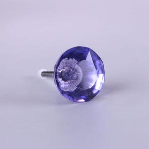 Può includere: Un pomello per armadio in vetro viola sfaccettato con una vite argentata. Il pomello è rotondo con un aspetto simile a una gemma, che riflette la luce. Questo hardware decorativo è adatto per cassetti, armadi o mobili.