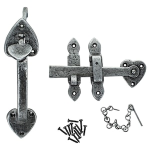 May include: Silver-toned heart-shaped door latch with a sliding bolt and a separate handle. The latch is attached to a wooden door with screws. The handle has a heart-shaped design and a small chain attached to it.