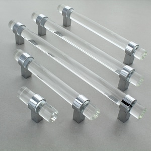 Peut inclure: Ensemble de poignées de meubles en acrylique transparent avec des détails chromés polis. Les poignées sont cylindriques et montées sur des bases carrées argentées. Idéal pour les projets de décoration intérieure.
