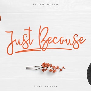 May include: Introducing Just Because font family, a handwritten script font with a casual and playful feel. The font is shown in orange on a white wooden background.