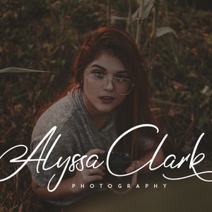 May include: A woman with red hair and glasses is holding a camera in a field of tall grass. The text "Alyssa Clark Photography" is written in a cursive font below her.