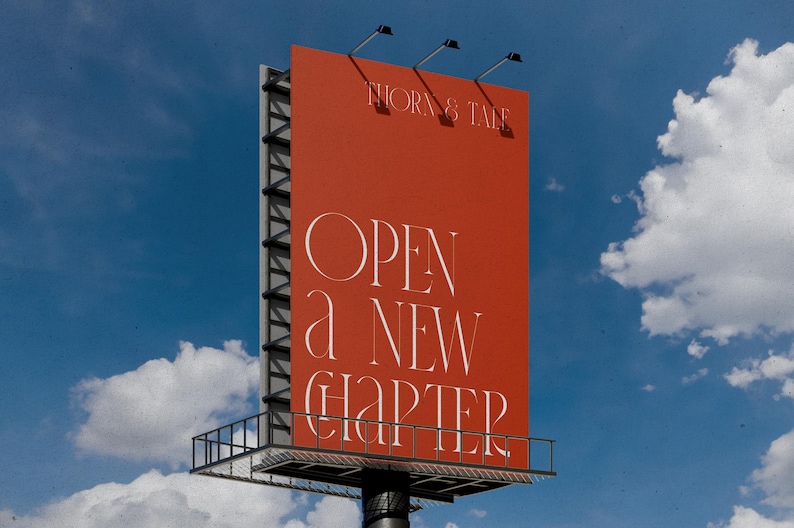 May include: A large billboard against a blue sky with white clouds. The billboard is a vibrant orange-red color and features the text "THORN & TALE" at the top and "OPEN a NEW CHAPTER" in elegant white lettering. The structure has a metal frame.