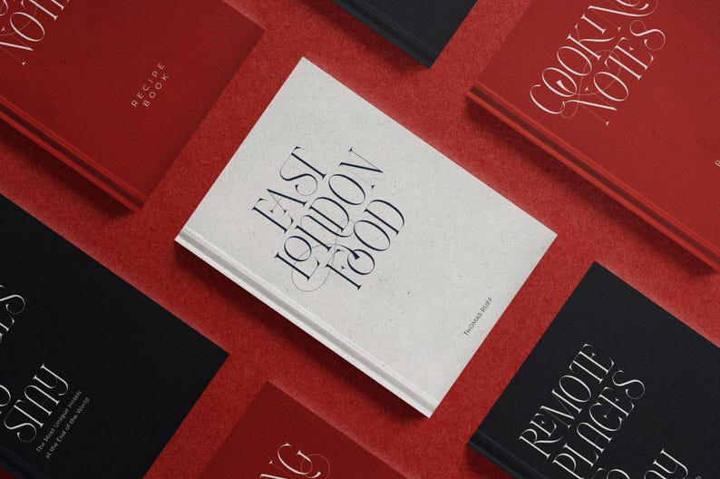 May include: A collection of hardcover books with titles including "East London Food," "Cooking Notes," and "Remote Places." The books are in red, black, and white, arranged on a red surface. The titles are in elegant, stylized fonts.