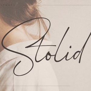 Puede incluir: Una fuente manuscrita llamada "Stolid Script" en negro sobre un fondo beige claro.