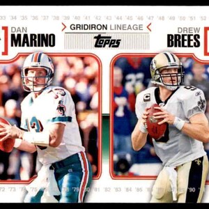 May include: A Topps Gridiron Lineage trading card featuring Dan Marino and Drew Brees. Marino is wearing a Miami Dolphins uniform and Brees is wearing a New Orleans Saints uniform. The card has a red border and the text "Gridiron Lineage" is printed in white.